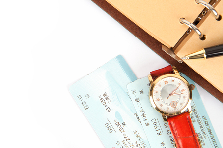 Notebook and a watch with train tickets on white backgroundのeditorial素材