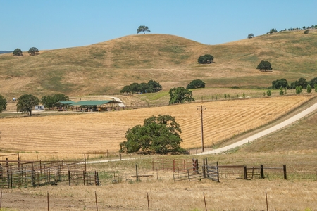 CALIFORNIA, USA - JUNE 10, 2006. Panoramic view of a plowed farm field within a ranch at the foot of some hills in the so-called Golden State, California, United States.のeditorial素材