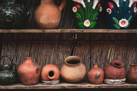 Group of vases and clay pots on wooden shelf