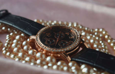women's wristwatch in a bronze frame. they lie in pearlsの写真素材