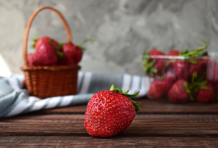 big bright juicy fresh strawberries with a basket of strawberries on the backgroundの写真素材