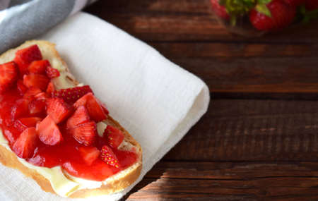 sweet sandwich with butter, strawberry jam and slices of fresh strawberriesの写真素材