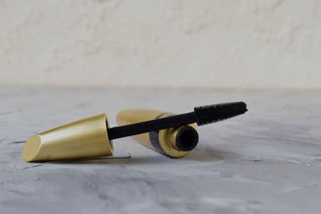 Open mascara and brush close-up, gold tube, black ink, mascara containerの写真素材