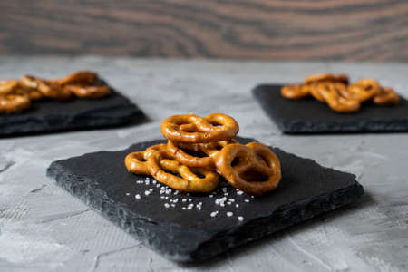 fresh crispy mini pretzels with sea salt lined with slate backingの写真素材