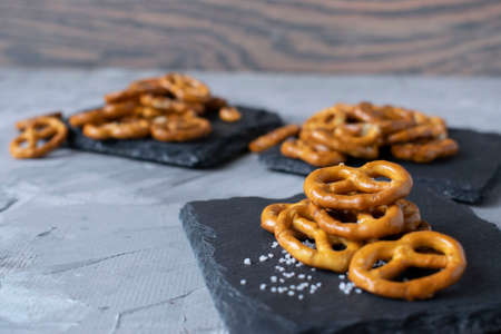 crispy mini pretzels with sea salt will be laid out on a black slate substrateの写真素材