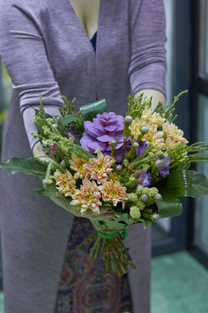 The girl is holding a bouquet of greens, leaves. Forest, natural eco bouquet.の写真素材