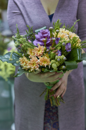 The girl is holding a bouquet of greens, leaves. Forest, natural eco bouquet.の写真素材