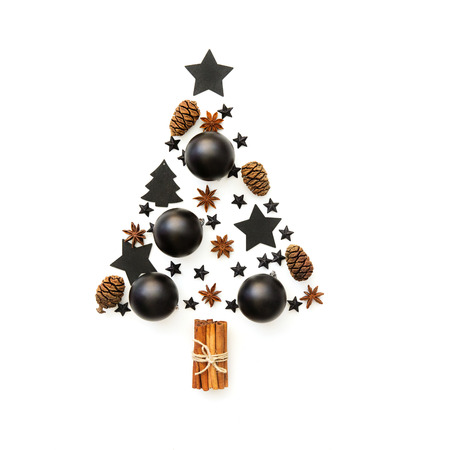 Christmas tree made from black decorations on white background. holiday and celebration creative concept. New Year and Christmas postcard or invitation. Flat lay の写真素材