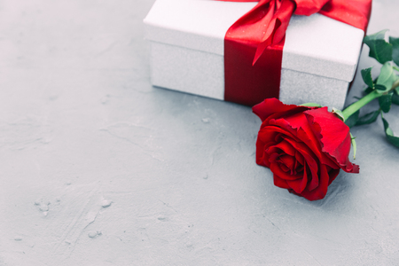Beautiful red rose and gift box on wooden background with copy space. valentine's day present.の写真素材
