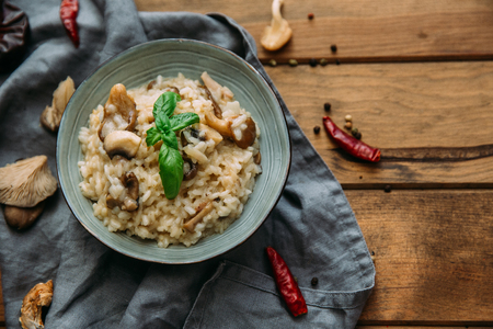 Risotto with mushrooms on an old wooden background. Rustic style.の写真素材