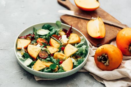 Fresh salad with fruits and greens on white wooden background close up. Healthy food.の写真素材