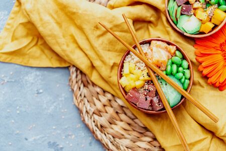 Fresh seafood recipe. Shrimp poke bowl with fresh prawn, brown rice, cucumber, pickled sweet onion, radish, soy beans edamame portioned with black and white sesame. Food concept poke bowlの写真素材