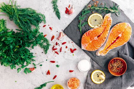 Fresh raw salmon steak with herbs and spices, top viewの写真素材