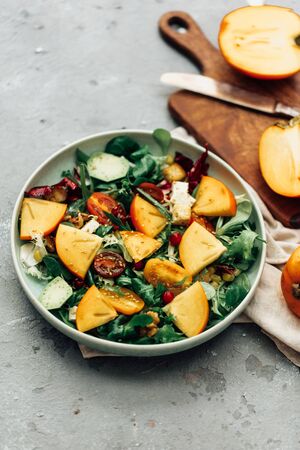 Fresh salad with fruits and greens on white wooden background close up. Healthy food.の写真素材