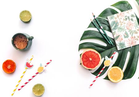 Flat lay of minimal workspace, Top view of fresh summer fruits composed on top of bright green Monstera leafの写真素材