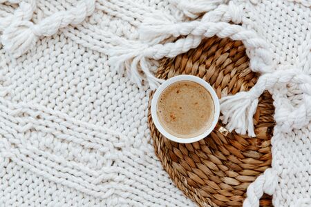 Flat lay cup of coffee, plaid blanket on rattan straw. Morning breakfast. Minimal modern interior design concept. Still Life conceptの写真素材