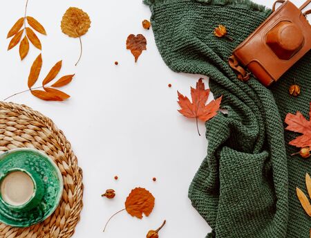 Flat lay with Coffee cup and old retro camera with autumn fall leaves on white backgroundの写真素材