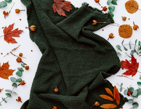 Green napkin with autumn leaves on white background 