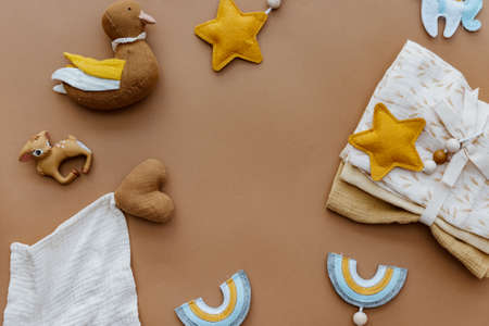 Knited toys for kids, baby staff, newborn accessory on brown background. Set of gender neutral newborn accessories. Flat lay, top viewの写真素材