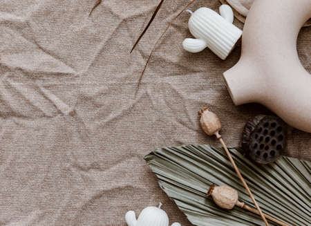 Wedding stationery mock-up scene. linen tablecloth background with ceramic vase, dry palm leaf and candle. Feminine still life composition.の写真素材