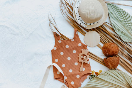 Baby summer background, Flat lay retro child swimsuit with palm leaf and accessories. Summer kids holiday concept, top view, flat layの写真素材