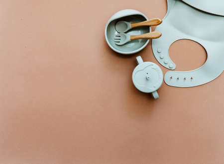Set of green dishware on brown background, flat lay with space for text. Serving baby first foodの写真素材