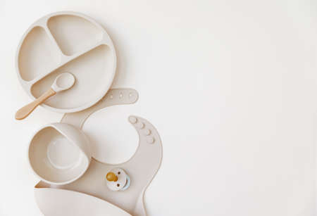 Flat lay beige silicone dishware for baby. Serving kid first feeding concept. copy space, top viewの写真素材