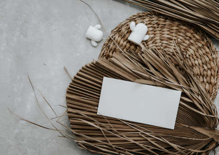 Summer stationery still life with blank paper card and palm leaves on stone background. Minimal boho Mockup invitation.の写真素材