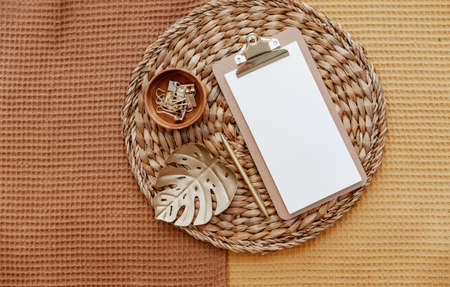 Mockup of clipboard with blank paper with office supplies and decorations. Top view with copy space, flat lay. Boho minimal concept for bloggers, freelance top viewの写真素材