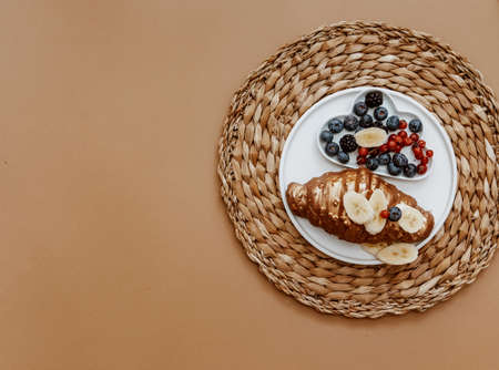 Fresh croissant and berries on brown background, top view, flat lay.の写真素材