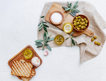 Olive oil and bread fresh branch of olives on white marble background directly above.の写真素材