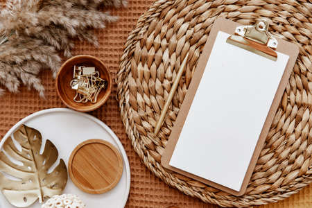 Flat lay blank paper clipboard. Top view home office desk table, minimal style feminine workspace....