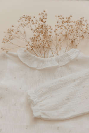 natural material concept. Soft baby bodysuit on beige background. Bohemian babyの写真素材