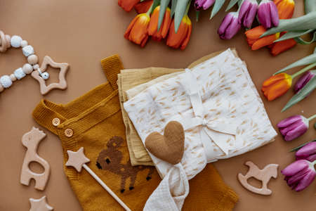 Newborn baby accessory and wooden toys in a box on a brown background. Top view, flat lay. Baby shower. Newborn stuffの写真素材