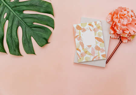 Top View Minimal tropic background with notebook, flower on pink pastel background