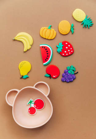 Bright silicone dishware on light background. Serving baby, first feeding concept. Flat lay, copy space, top viewの写真素材