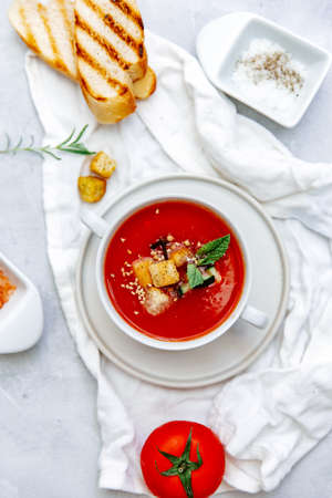 Fresh Cold tomato soup with bread on table. Summer Spanish food. Top view, copy spaceの写真素材