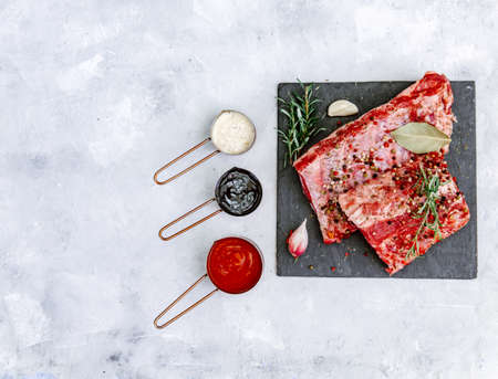 Raw beef ribs, fresh meat with sauce, top view, flat lay, copy space