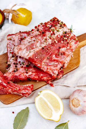 Raw pork ribs, fresh meat with mustard sauce and lemon, top view, flat lay, copy spaceの写真素材
