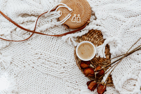 Flat lay cup of coffee and roses over plaid blanket on rattan straw. Morning breakfast. Minimal modern interior design concept. Still life conceptの写真素材