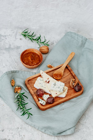Delicious blue cheese with honey, walnuts and grapes on wooden backgroundの写真素材