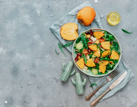Diet salad with persimmon, top view, Fresh Salad with persimmons, walnuts, arugula. Healthy foodの写真素材