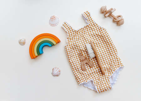 Summer kid's vacation concept - swimsuit on neutral beige background, minimal holiday fashion baby. Top view, flat layの写真素材