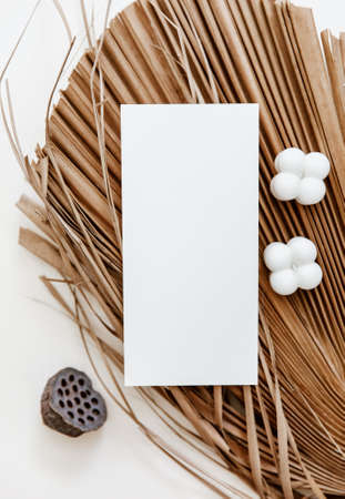 Summer stationery minimal mock-up. Blank card, palm leaves, beige textured table background. Wedding mock up. Flat lay, top viewの写真素材