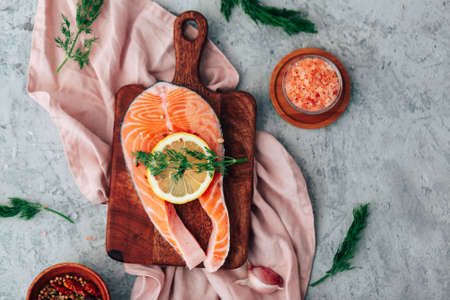 Fresh raw Salmon. fish fillet with herbs and lemon. healthy food, diet or cooking conceptの写真素材