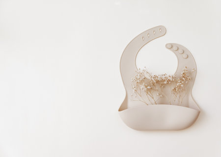 Silicone baby beige bib on neutral background. Top view, flat layの写真素材