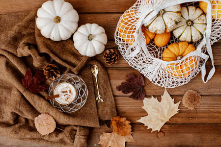 Flat lay Autumn still life with a coffee cup and pumpkins on wooden background. Stylish autumn composition.の写真素材
