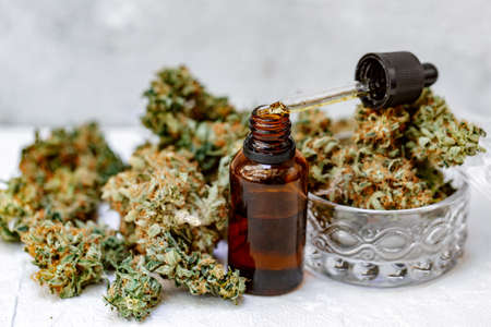 Marijuana buds, oil pills, cbd recreation. Fresh cannabis leaf close up, isolated on white background. Home relaxation, pastime therapy. Alternative medicine.の写真素材