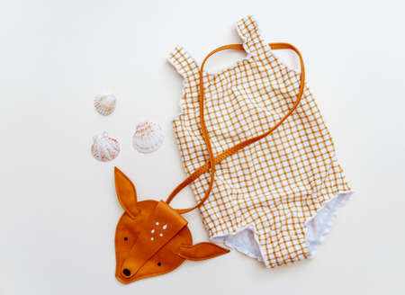 Summer kid's vacation concept - swimsuit on neutral beige background, minimal holiday fashion baby. Top view, flat layの写真素材