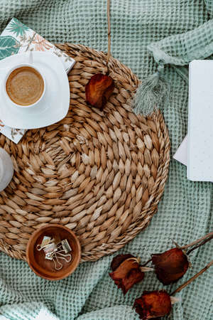 Cozy flat lay with coffee cup and dried roses. Lifestyle blogger concept, rustic nordic backgroundの写真素材